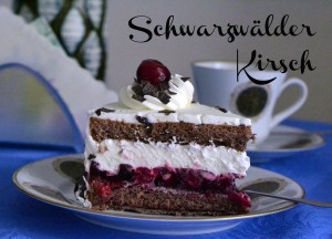 Kirschen und Sahne mir Kirschwaasser abgeschmeckt in dunklem Biskuit. Garniert mit Sahnetuffs, Schoko-Raspeln und Kirschen